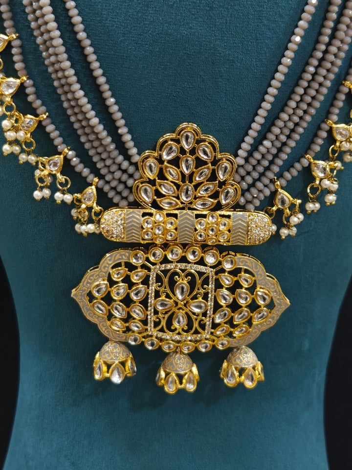 Close-up of an ornate traditional Grey Meenakari gold Long jewellery set and earrings with Kundan, Meenakari work, crystal beads, pearls and American Diamonds. Wedding function styling with a premium Meenakari imitation necklace. Perfect Meenakari necklace set for weddings and festivals.