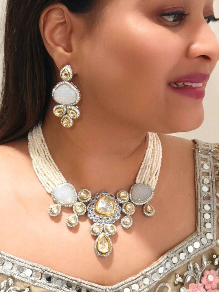 A woman in a Gold embroidered outfit smiles, showcasing the Peacoski GreyTamanna Necklace Set and matching earrings. Her soft makeup highlights the elegance of this statement jewelry ensemble.