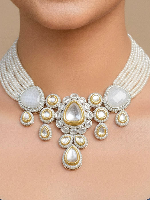 Close-up of a woman wearing an ornate traditional Grey Collar Kundan jewellery set and earrings with American diamonds, Monalisa stone, Pearls, Kundan and Colored Stones. Festive Diwali outfit paired with a premium Kundan jewelry piece. Woman wearing trending Kundan artificial jewelry for wedding season in India.