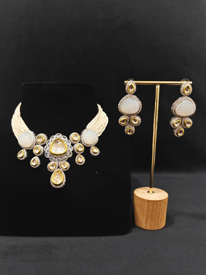 Close-up of an ornate traditional Grey Collar Kundan jewellery set and earrings with American diamonds, Monalisa stone, Pearls, Kundan and Colored Stones. Festive Diwali outfit paired with a premium Kundan jewelry piece. A trending Kundan artificial jewelry for wedding season in India.