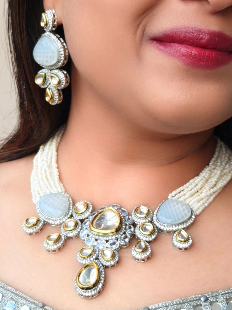A woman in a Gold embroidered outfit smiles, showcasing the Peacoski GreyTamanna Necklace Set and matching earrings. Her soft makeup highlights the elegance of this statement jewelry ensemble.