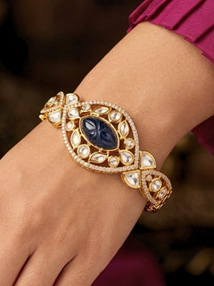 Close-up of a woman wearing an ornate traditional (Gold Polish) Navy Blue Bracelet with Polki, American Diamond and Navy Blue Carved Stone. Woman showcasing a premium artificial Polki bracelet for wedding celebrations. Modern saree styling featuring a delicate Polki bracelet.
