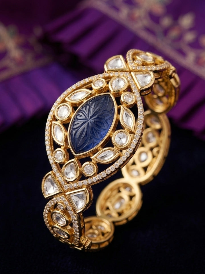 Close-up of an ornate traditional (Gold Polish) Navy Blue Bracelet with Polki, American Diamond and Navy Blue Carved Stone. Woman showcasing a premium artificial Polki bracelet for wedding celebrations. Modern saree styling featuring a delicate Polki bracelet.