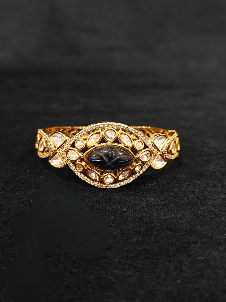 Close-up of an ornate traditional (Gold Polish) Navy Blue Bracelet with Polki, American Diamond and Navy Blue Carved Stone. Woman showcasing a premium artificial Polki bracelet for wedding celebrations. Modern saree styling featuring a delicate Polki bracelet.