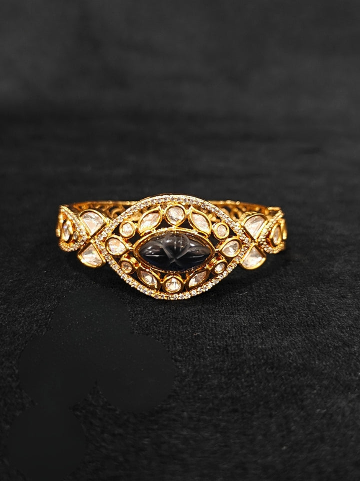 Close-up of an ornate traditional (Gold Polish) Navy Blue Bracelet with Polki, American Diamond and Navy Blue Carved Stone. Woman showcasing a premium artificial Polki bracelet for wedding celebrations. Modern saree styling featuring a delicate Polki bracelet.