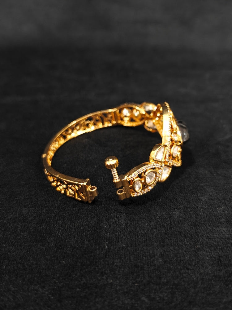 Close-up of an ornate traditional (Gold Polish) Navy Blue Bracelet with Polki, American Diamond and Navy Blue Carved Stone. Woman showcasing a premium artificial Polki bracelet for wedding celebrations. Modern saree styling featuring a delicate Polki bracelet.
