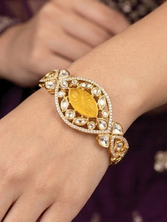 Close-up of a woman wearing an ornate traditional (Gold Polish) Yellow Bracelet with Polki, American Diamond and Yellow Carved Stone. Woman showcasing a premium artificial Polki bracelet for wedding celebrations. Modern saree styling featuring a delicate Polki bracelet.