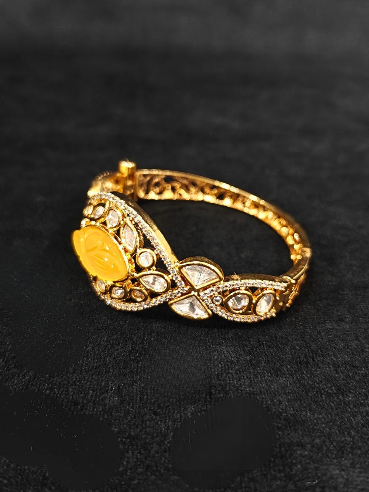 Close-up of an ornate traditional (Gold Polish) Yellow Bracelet with Polki, American Diamond and Yellow Carved Stone. Woman showcasing a premium artificial Polki bracelet for wedding celebrations. Modern saree styling featuring a delicate Polki bracelet.