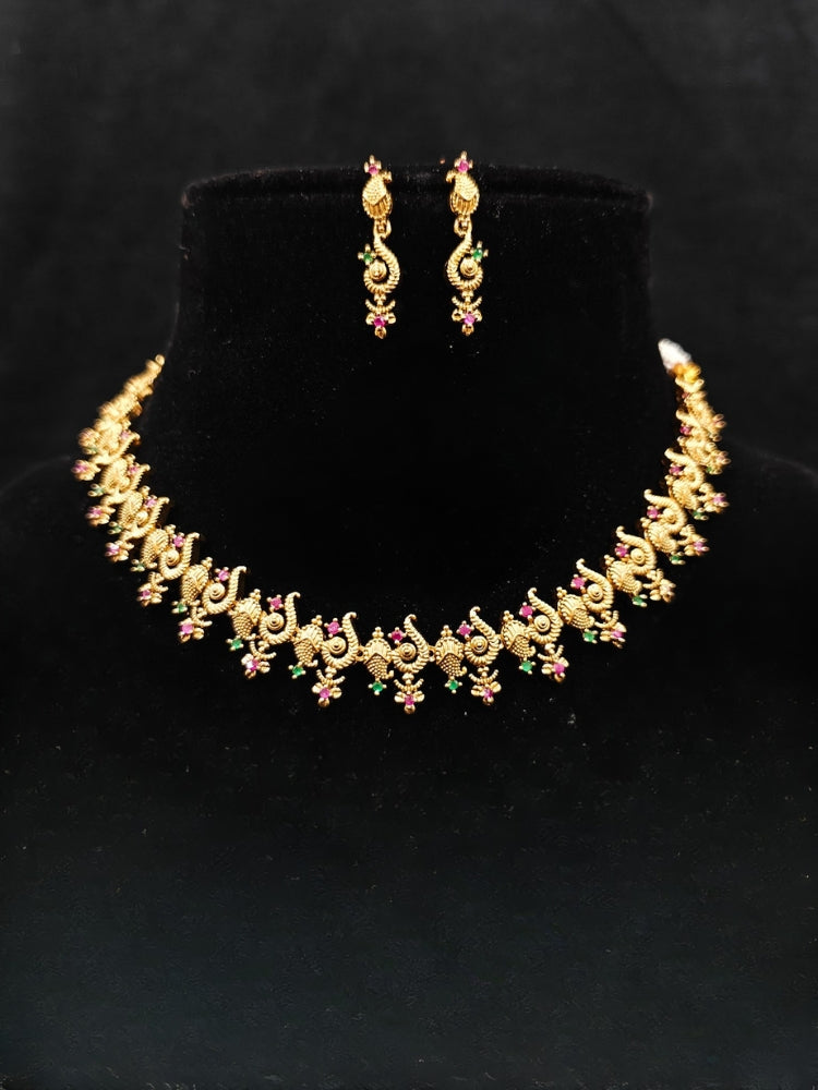 Close-up of an ornate traditional (Gold Polish) Collar jewellery set and earrings with Colored Stone and American Diamond. Mehendi ceremony look completed with a Colored Stone jewelry set. Festive Diwali outfit paired with a colorful Colored Stone necklace.