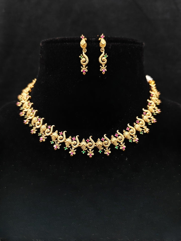 Close-up of an ornate traditional (Gold Polish) Collar jewellery set and earrings with Colored Stone and American Diamond. Mehendi ceremony look completed with a Colored Stone jewelry set. Festive Diwali outfit paired with a colorful Colored Stone necklace.