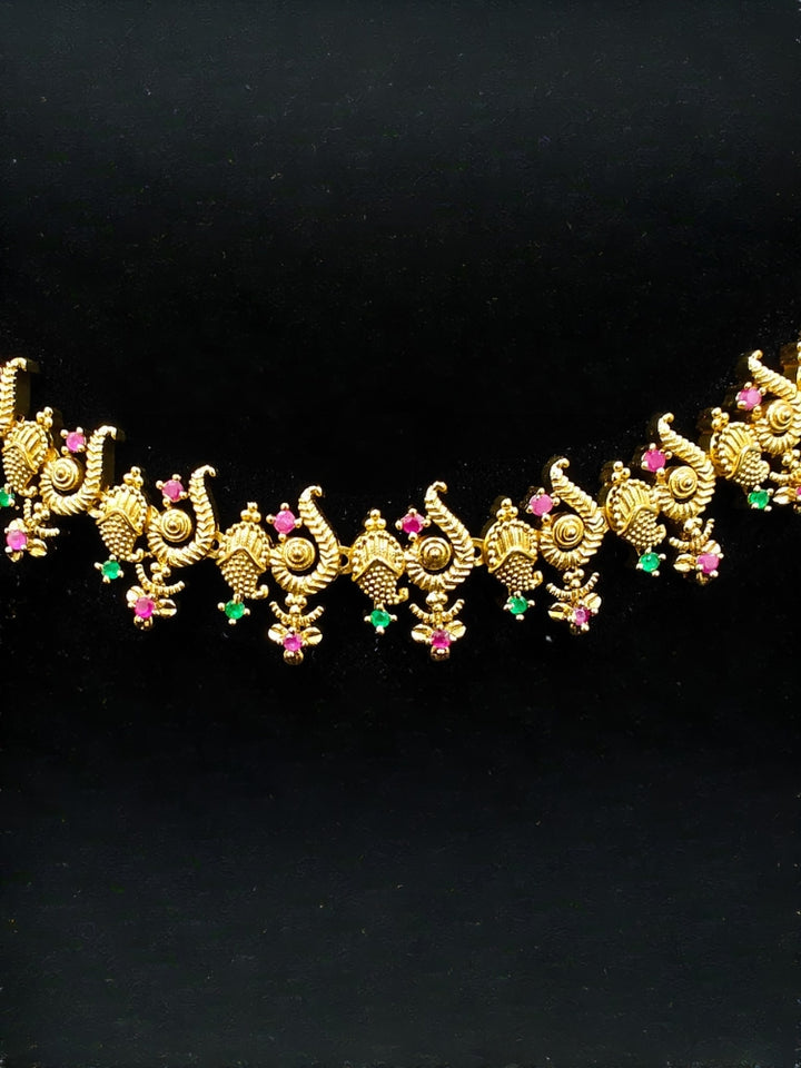 Close-up of an ornate traditional (Gold Polish) Collar jewellery set and earrings with Colored Stone and American Diamond. Mehendi ceremony look completed with a Colored Stone jewelry set. Festive Diwali outfit paired with a colorful Colored Stone necklace.