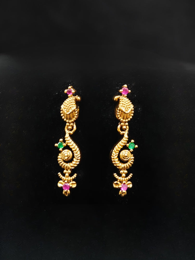 Close-up of an ornate traditional (Gold Polish) Collar jewellery set and earrings with Colored Stone and American Diamond. Mehendi ceremony look completed with a Colored Stone jewelry set. Festive Diwali outfit paired with a colorful Colored Stone necklace.