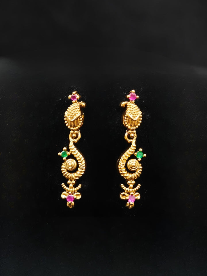 Close-up of an ornate traditional (Gold Polish) Collar jewellery set and earrings with Colored Stone and American Diamond. Mehendi ceremony look completed with a Colored Stone jewelry set. Festive Diwali outfit paired with a colorful Colored Stone necklace.