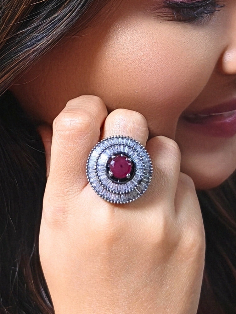 Close-up of a woman wearing an ornate Western (Black Polish Victorian Finish) Red Diamond Ring with American Diamond and Colored Stones. Woman styling a premium imitation American Diamond ring with festive attire. Party wear styling with a premium imitation jewelry American Diamond ring.
