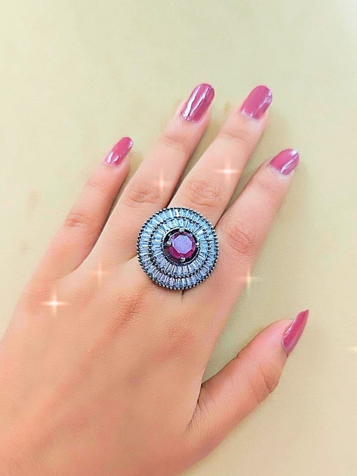 Close-up of a woman wearing an ornate Western (Black Polish Victorian Finish) Red Diamond Ring with American Diamond and Colored Stones. Woman styling a premium imitation American Diamond ring with festive attire. Party wear styling with a premium imitation jewelry American Diamond ring.
