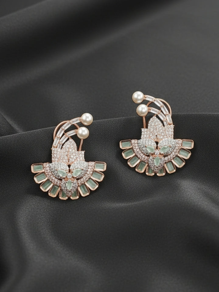 Close-up of an ornate Indo-western Mint Green (Rose gold Polish) Diamond Studs Earrings with American Diamond and Colored Stones. Mehendi function outfit styled with a lightweight American Diamond Studs Earrings. 