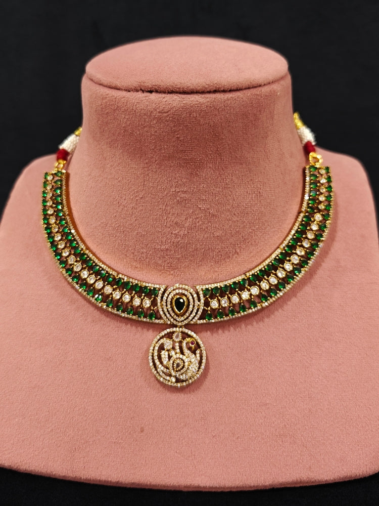 A gorgeous artificial diamond and green colored stone  necklace paired with diamond earrings. This artificial diamond jewelry set offers a traditional yet modern touch for Indian brides, designed to add elegance and sophistication to any occasion.