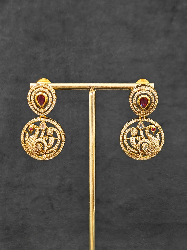 A gorgeous artificial diamond and Red colored stone necklace paired with diamond earrings. This artificial diamond jewelry set offers a traditional yet modern touch for Indian brides, designed to add elegance and sophistication to any occasion.