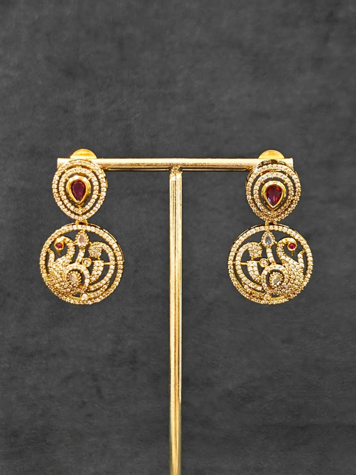 A gorgeous artificial diamond and Red colored stone necklace paired with diamond earrings. This artificial diamond jewelry set offers a traditional yet modern touch for Indian brides, designed to add elegance and sophistication to any occasion.