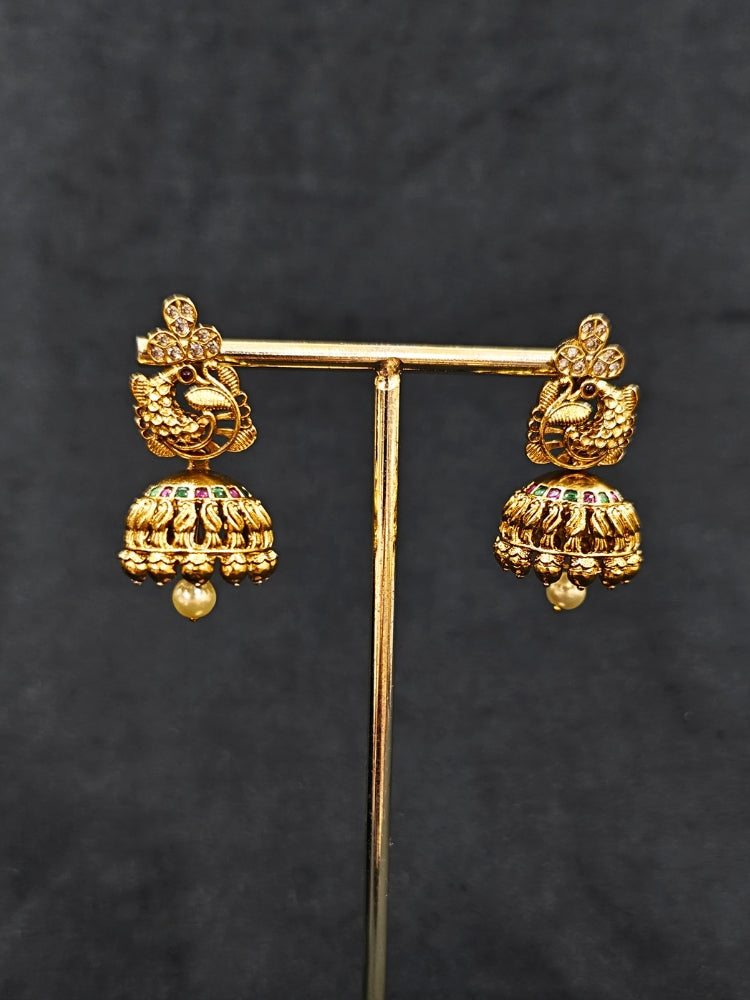 Close-up of an ornate traditional (Gold Polish) Collar jewellery set and earrings with Colored Stones. Festive Diwali outfit paired with a colorful Colored Stone necklace. Mehendi ceremony look completed with a Colored Stone jewelry set.