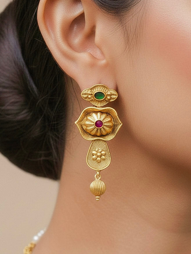 Close-up of a woman wearing an ornate traditional (Bright Gold Polish) Collar jewellery set and earrings with Pink and Green Colored Stone. Woman pairing a traditional Colored Stone necklace with a silk saree. Festive Diwali look enhanced with an imitation Colored Stone Necklace Set.
