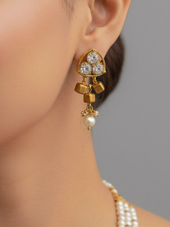 Close-up of a woman wearing an ornate Indo-Western White and Gold Pearl Layered Jewellery set and Earring with Pearls and American Diamond. Festive celebration look enhanced with traditional Pearl jewelry. Close-up of enamel work in Meenakari artificial Pearl jewelry.
