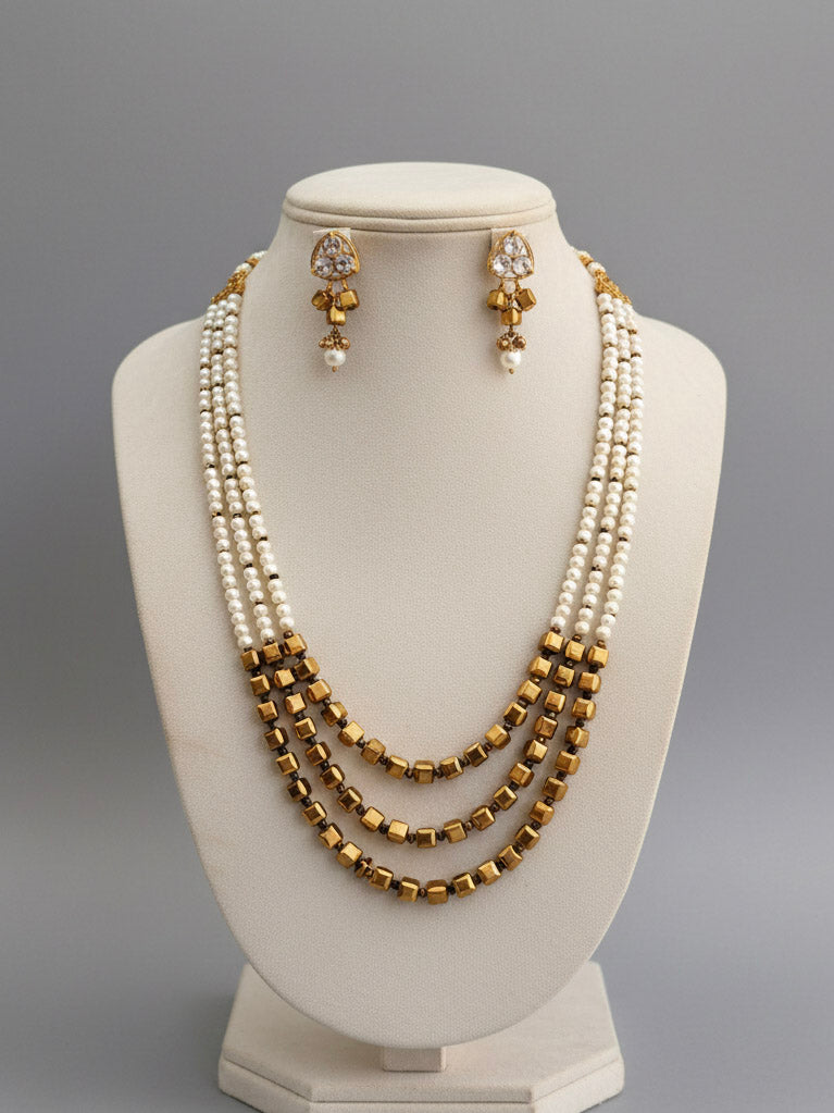 Close-up of an ornate Indo-Western White and Gold Pearl Layered Jewellery set and Earring with Pearls and American Diamond. Festive celebration look enhanced with traditional Pearl jewelry. Close-up of enamel work in Meenakari artificial Pearl jewelry.