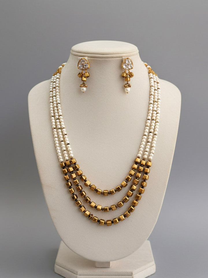 Close-up of an ornate Indo-Western White and Gold Pearl Layered Jewellery set and Earring with Pearls and American Diamond. Festive celebration look enhanced with traditional Pearl jewelry. Close-up of enamel work in Meenakari artificial Pearl jewelry.