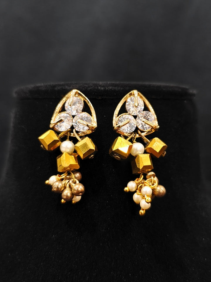 Close-up of an ornate Indo-Western White and Gold Pearl Layered Jewellery set and Earring with Pearls and American Diamond. Festive celebration look enhanced with traditional Pearl jewelry. Close-up of enamel work in Meenakari artificial Pearl jewelry.