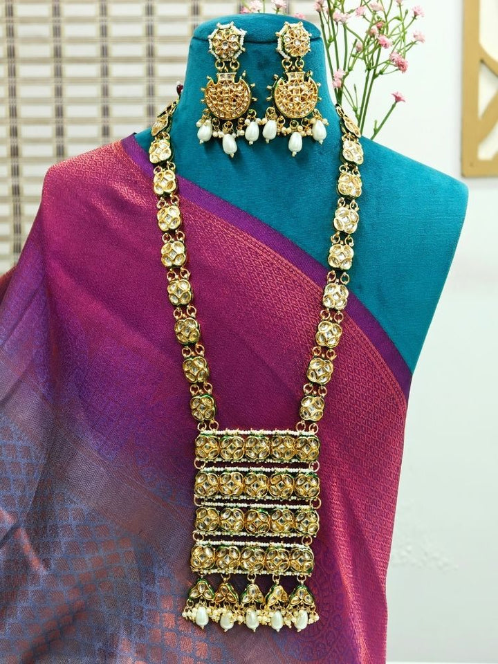 Close-up of an ornate traditional (Gold Polish) Long jewellery set and earrings with Kundan and Pearls. Festive saree styling with a premium artificial Kundan necklace. Mehendi ceremony look completed with a handcrafted Kundan jewelry set.