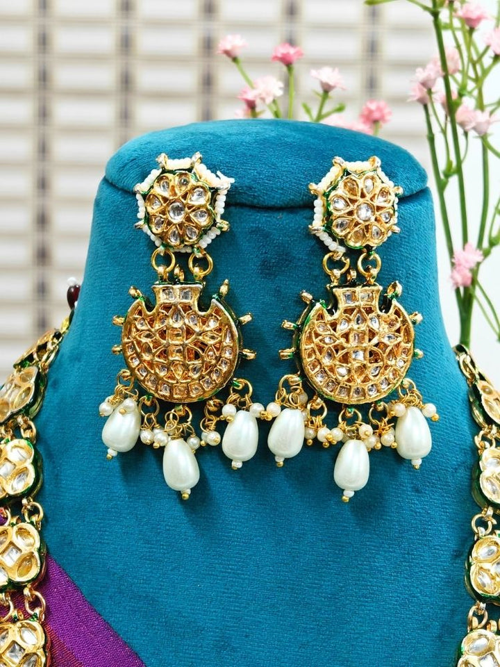 Close-up of an ornate traditional (Gold Polish) Long jewellery set and earrings with Kundan and Pearls. Festive saree styling with a premium artificial Kundan necklace. Mehendi ceremony look completed with a handcrafted Kundan jewelry set.