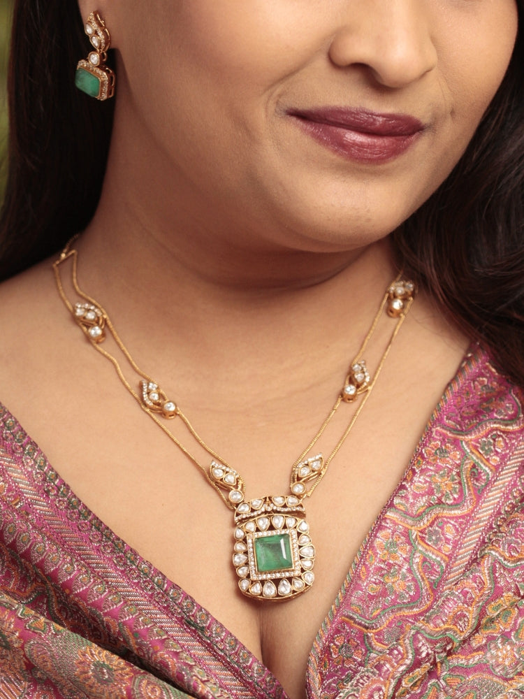 Close-up of a woman wearing an ornate traditional (Gold Polish) Mint Green jewellery set and earrings with Kundan and Colored Stones. Indo-western outfit styled with a lightweight Kundan necklace.  Festive saree styling with a premium artificial Kundan necklace.