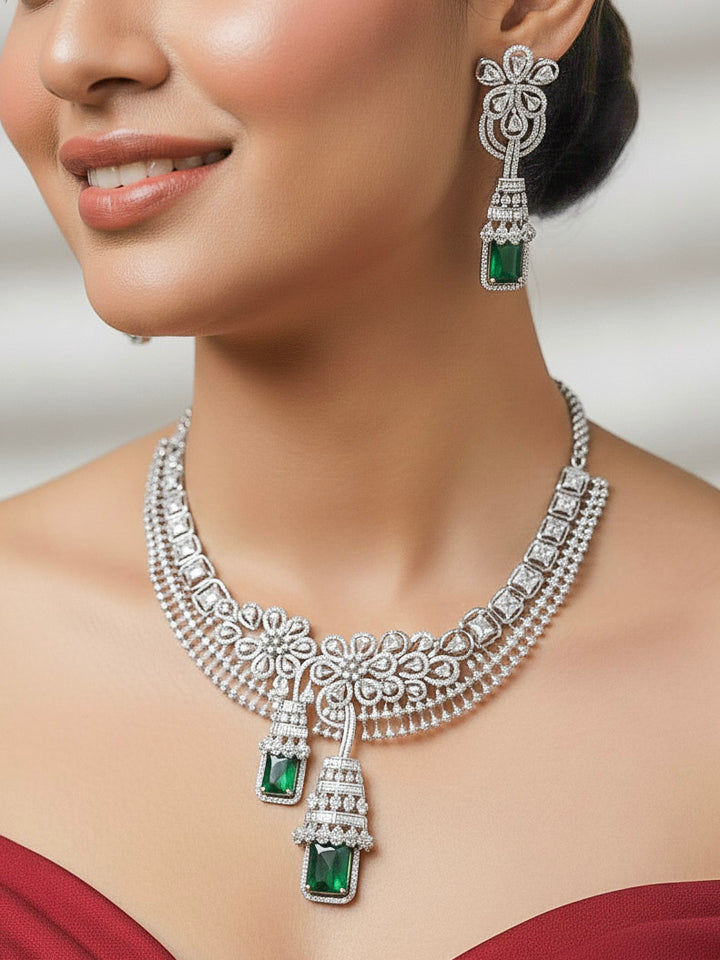 A bride-to-be wearing an exquisite artificial diamond necklace with green colored stone and matching earrings, designed for the perfect engagement look. This stunning artificial diamond jewelry set offers luxury and sophistication while being an affordable alternative to natural diamonds."