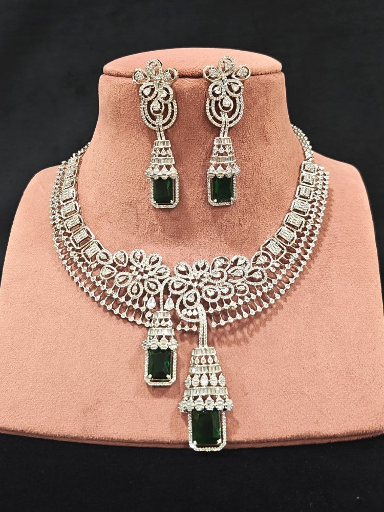 An exquisite artificial diamond necklace with green colored stone and matching earrings, designed for the perfect engagement look. This stunning artificial diamond jewelry set offers luxury and sophistication while being an affordable alternative to natural diamonds."