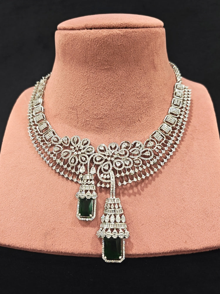 An exquisite artificial diamond necklace with green colored stone and matching earrings, designed for the perfect engagement look. This stunning artificial diamond jewelry set offers luxury and sophistication while being an affordable alternative to natural diamonds."