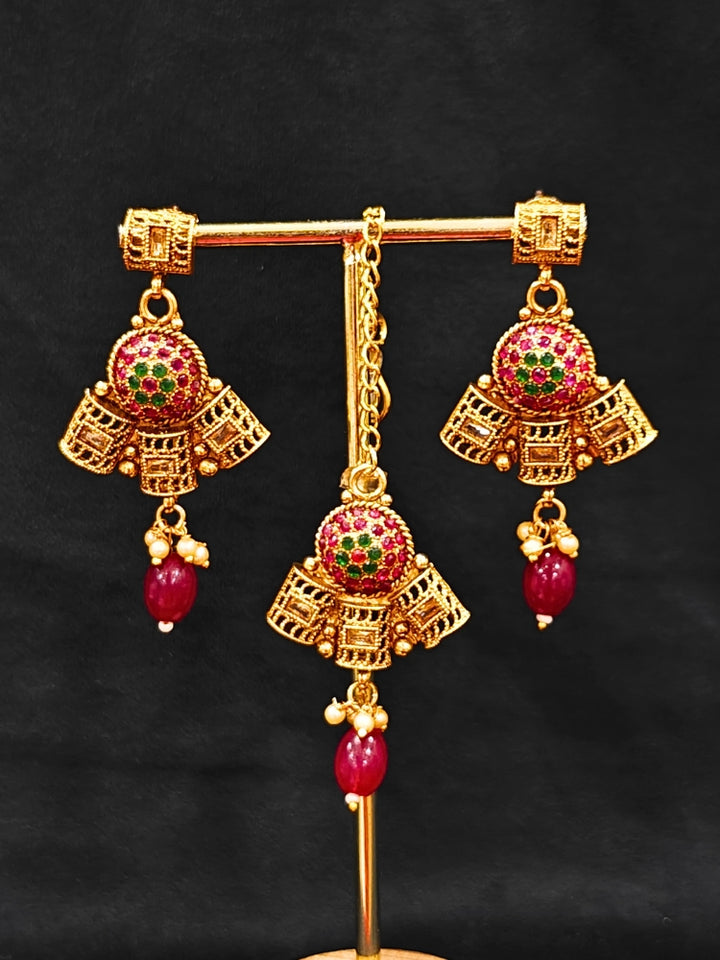 Close-up of an ornate traditional (Gold Polish) Long jewellery set and earrings and maangtikka with Colored Stones. Woman wearing lightweight artificial Colored Stone jewelry for long wedding functions. Saree look completed with elegant artificial Colored Stone jewelry for festive occasions.