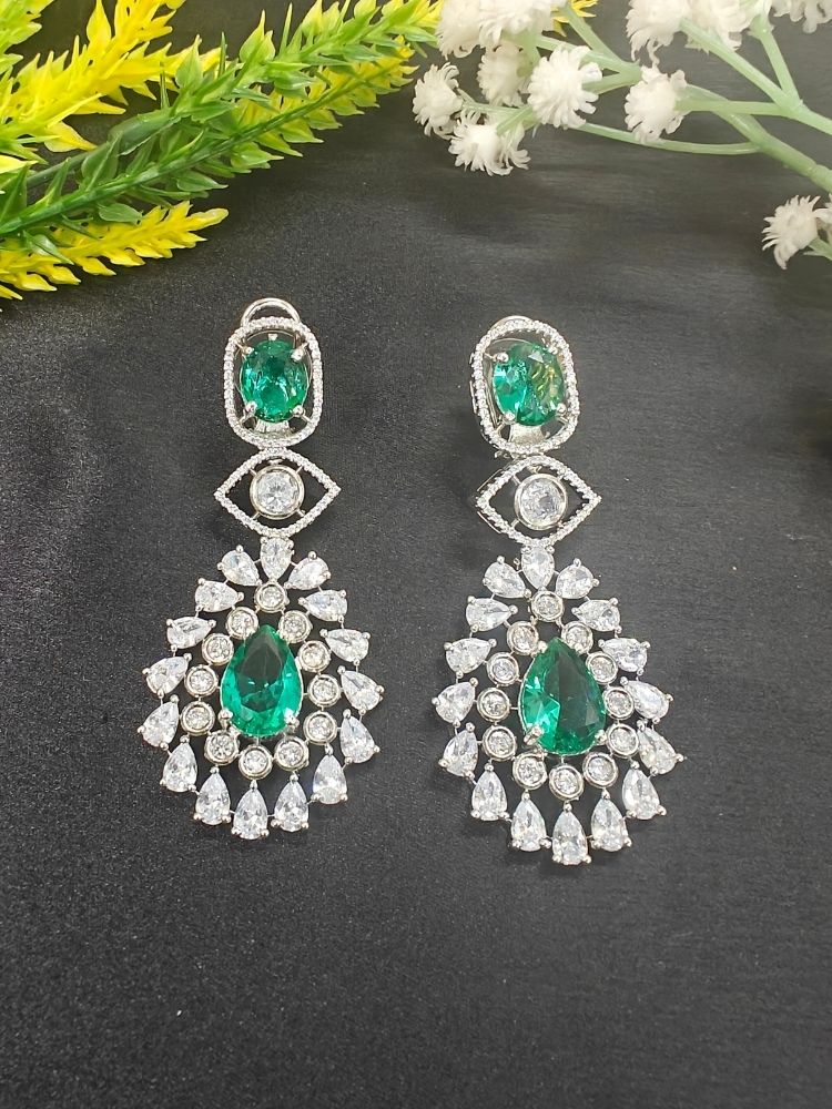 Ira Earrings—statement green brass earrings with American Diamonds and an intricate teardrop design. shown on a black background. 