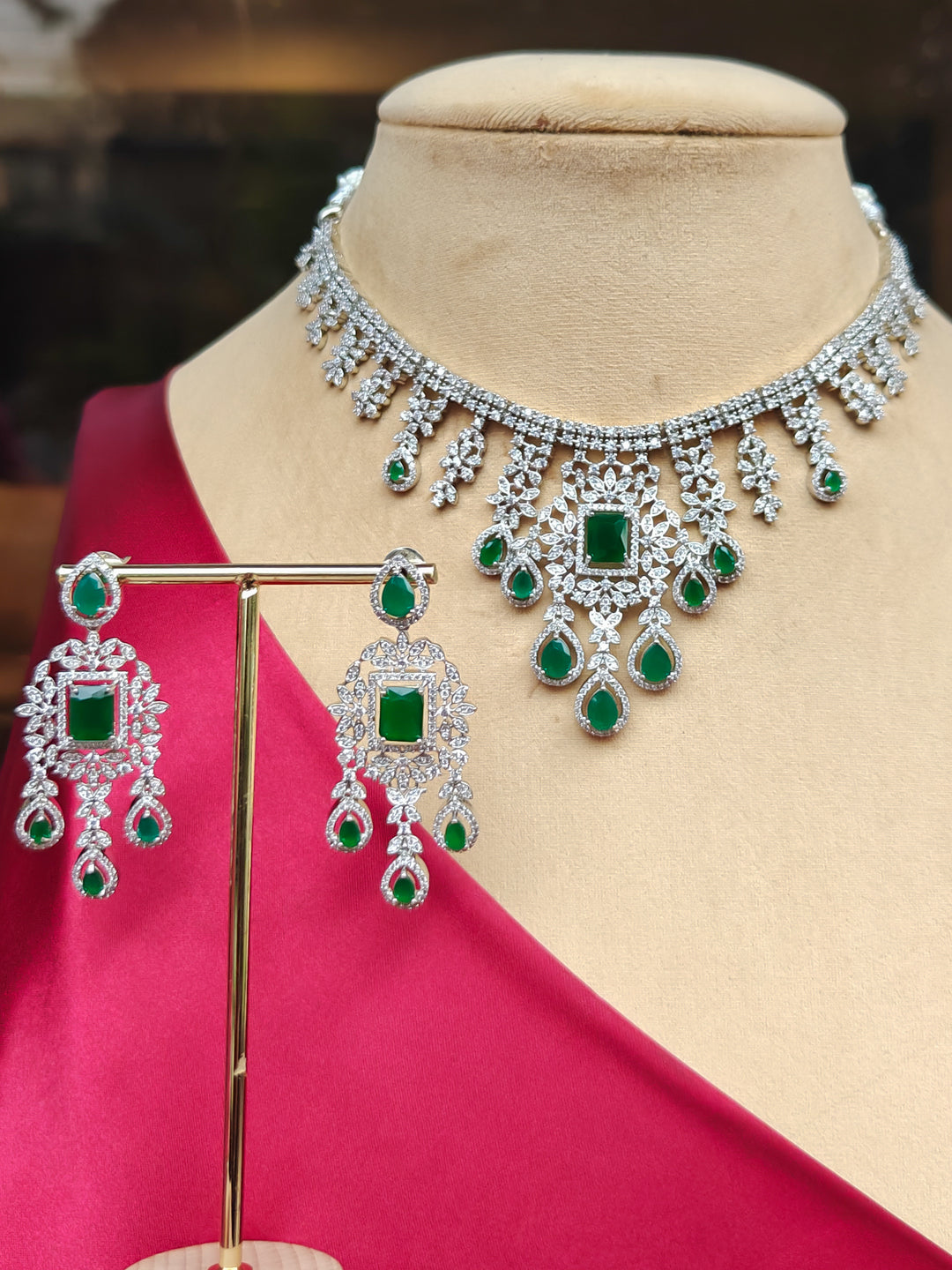 "Close-up of a woman wearing a stunning affordable artificial diamond necklace with green colored stone and matching earrings set, perfect for wedding guests and formal events. This luxury artificial diamond jewelry provides the brilliance of real diamonds at a fraction of the cost."
