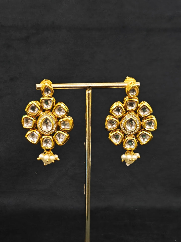 Close-up of an ornate traditional (Gold Polish) White Kundan  Choker jewellery set and earrings with Kundan and Pearls. Bride wearing a royal Kundan artificial necklace for wedding rituals. Close-up of detailed Kundan stones in artificial wedding jewelry. 