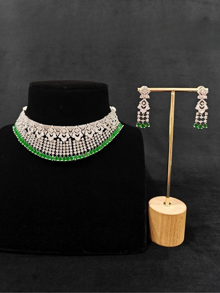 A glamorous artificial diamond and green colored stone necklace paired with chic earrings, perfect for bridal wear. This high-quality artificial diamond jewelry set is the ideal choice for modern brides looking for a budget-friendly option with timeless sparkle.