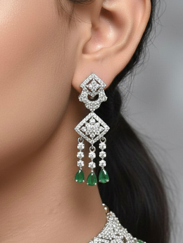 "A woman showcasing a beautiful artificial diamond and green colored stone  necklace and earrings set, ideal for festivals, family gatherings, and special celebrations in India. This elegant diamond jewelry provides the perfect blend of sparkle and tradition, with a modern twist."
