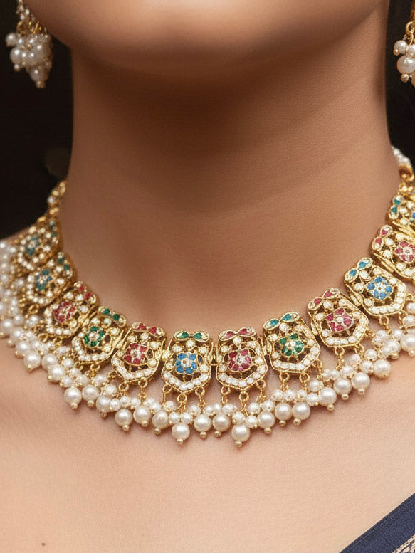 Close-up of a woman wearing an ornate traditional collar Navratan jadau gold jewellery set and jadau earrings with pearls and Navratan gemstones. Woman wearing a premium Jadau artificial jewelry set for reception night. Festive celebration look featuring a Jadau artificial necklace.
