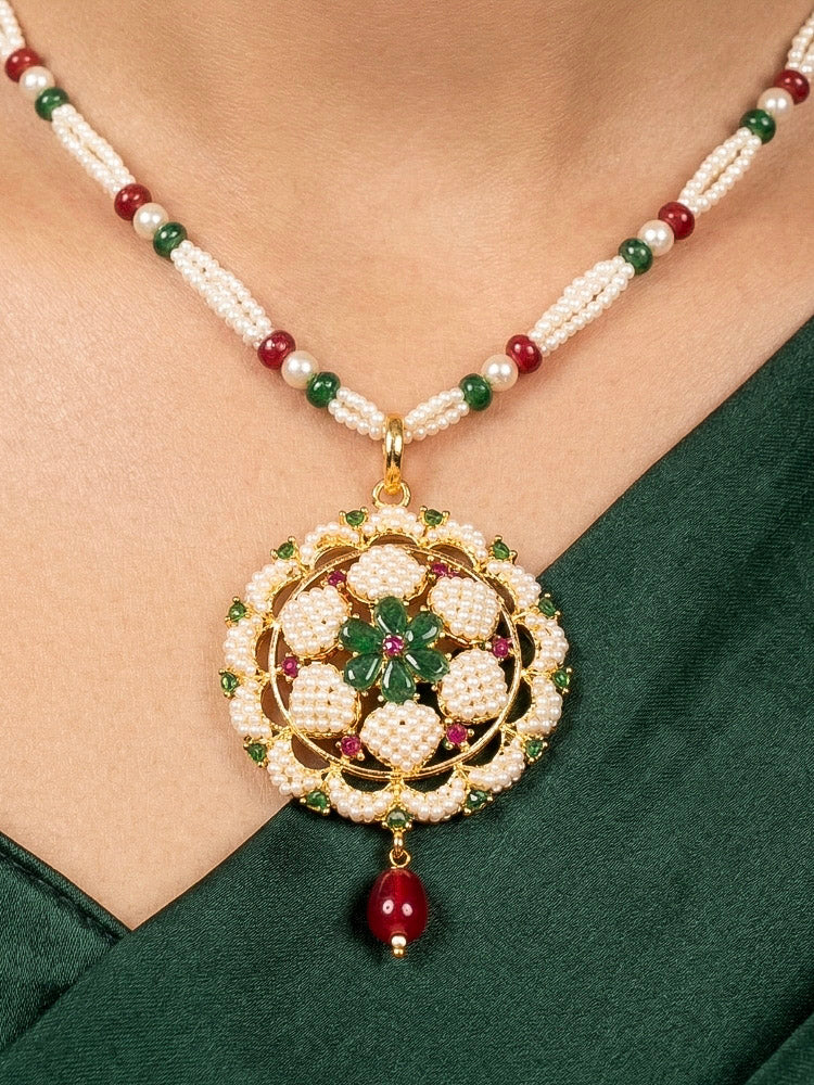 Close-up of a woman wearing an ornate traditional Pearl Pendant Set  earrings with Pearl and Colored Stones. Festive celebration look enhanced with traditional Pearl jewelry. Close-up of detailed enamel craftsmanship in Pearl jewelry.
