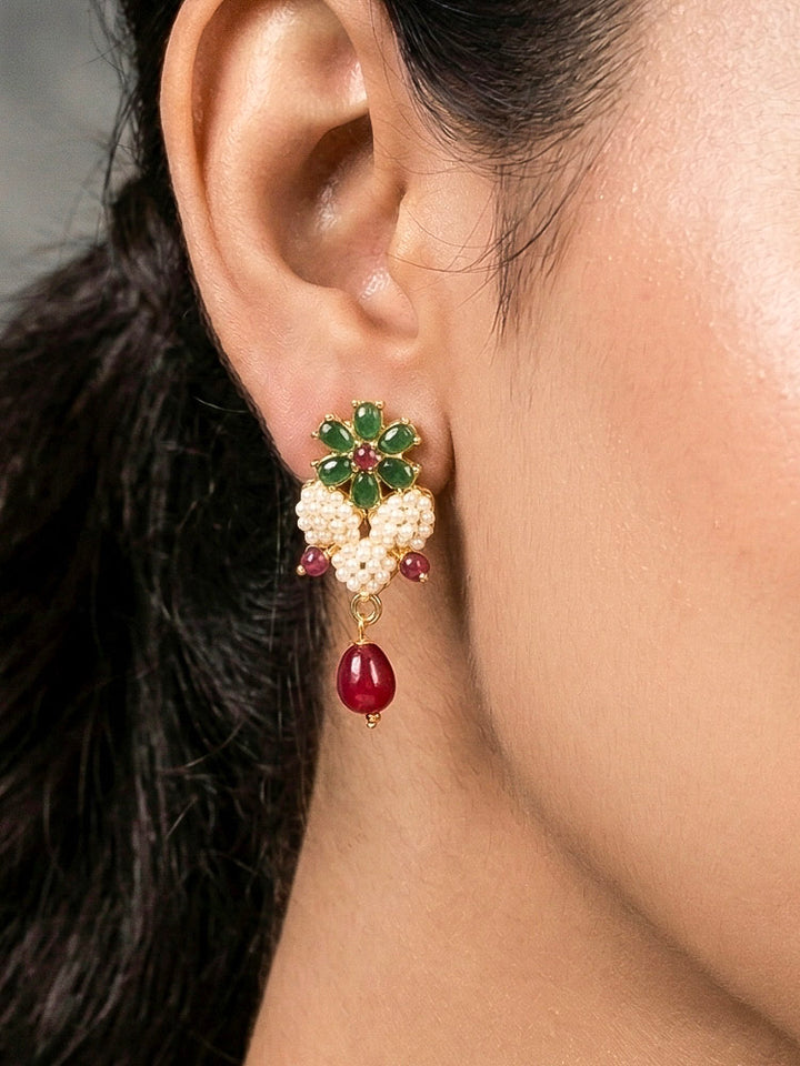 Close-up of a woman wearing an ornate traditional Pearl Pendant Set  earrings with Pearl and Colored Stones. Festive celebration look enhanced with traditional Pearl jewelry. Close-up of detailed enamel craftsmanship in Pearl jewelry.