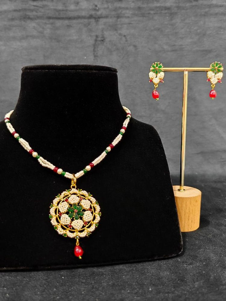 Close-up of an ornate traditional Pearl Pendant Set  earrings with Pearl and Colored Stones. Festive celebration look enhanced with traditional Pearl jewelry. Close-up of detailed enamel craftsmanship in Pearl jewelry.