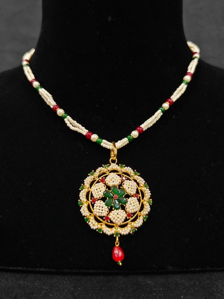 Close-up of an ornate traditional Pearl Pendant Set  earrings with Pearl and Colored Stones. Festive celebration look enhanced with traditional Pearl jewelry. Close-up of detailed enamel craftsmanship in Pearl jewelry.