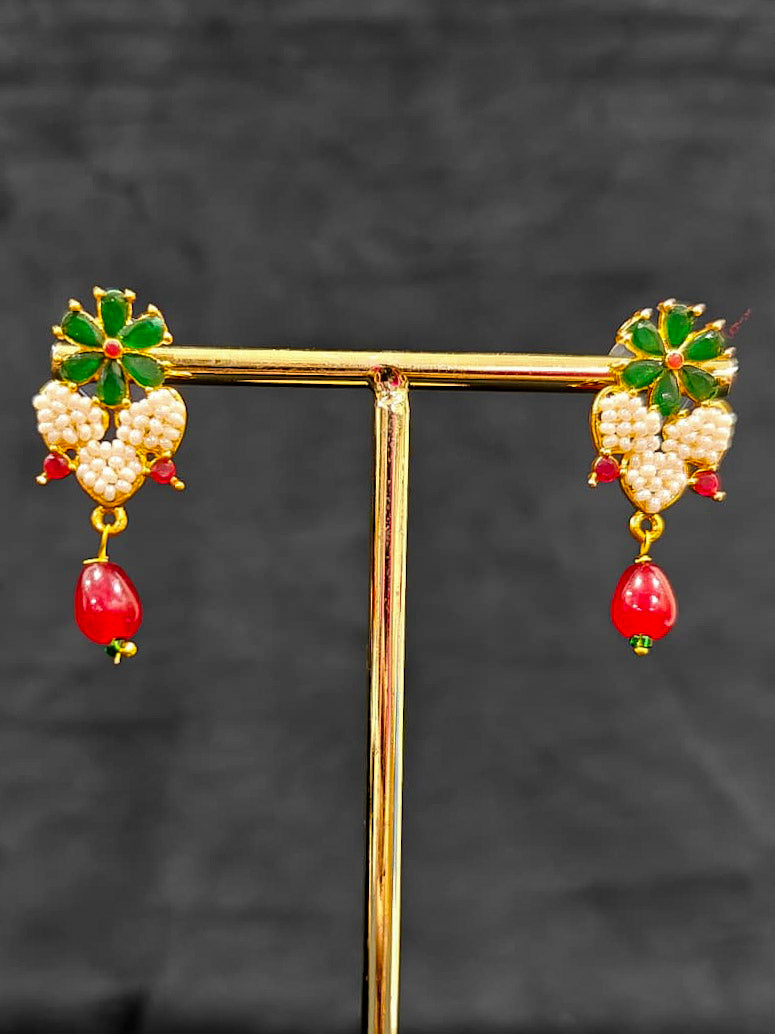 Close-up of an ornate traditional Pearl Pendant Set  earrings with Pearl and Colored Stones. Festive celebration look enhanced with traditional Pearl jewelry. Close-up of detailed enamel craftsmanship in Pearl jewelry.