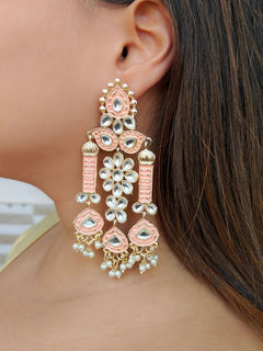 Close-up of a woman wearing an ornate traditional Peach Meenakari gold Long Earrings with Pearls, Kundan and Meenakari. Luxury look featuring a handcrafted Meenakari Earrings. Close-up of intricate Meenakari detailing in imitation Earrings.