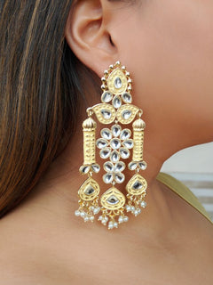 Close-up of a woman wearing an ornate traditional Yellow Meenakari gold Long Earrings with Pearls, Kundan and Meenakari. Saree styling inspiration with a statement Meenakari Earrings. Close-up of enamel work in Meenakari artificial wedding Earrings.