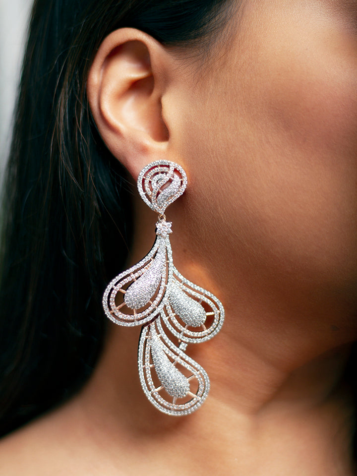 Close-up of a woman wearing an ornate Western American Diamond Rose Gold Earrings with American Diamond. Elegant party wear styled with high-quality imitation American Diamond earrings. Close-up of American diamond earrings styled for a reception party.